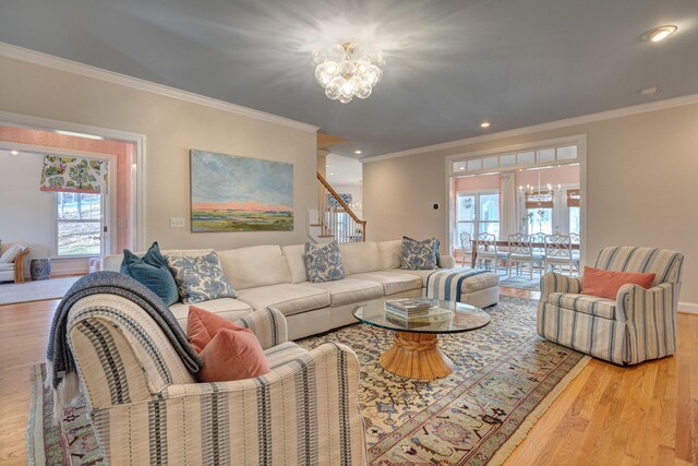 living area with an inviting chandelier, crown molding, recessed lighting, and wood finished floors