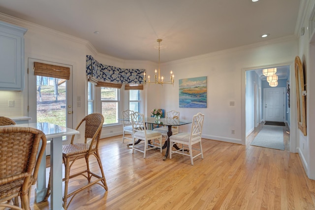 dining area featuring an inviting chandelier, crown molding, baseboards, and light wood-type flooring