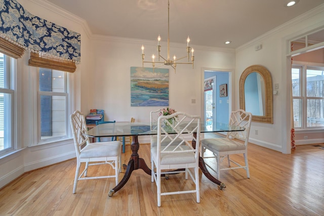 dining space with light wood-type flooring, baseboards, a chandelier, and crown molding