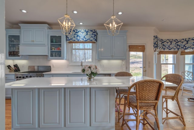 kitchen featuring premium range hood, stove, an inviting chandelier, and a sink