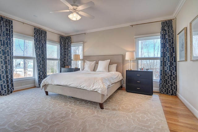 bedroom with light wood finished floors, multiple windows, and ornamental molding