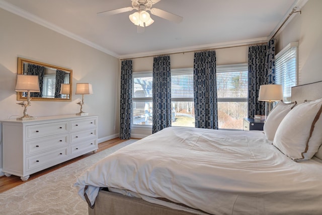 bedroom with crown molding, multiple windows, light wood-type flooring, and ceiling fan