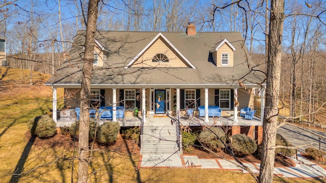 view of front of home with stairway, a porch, and a chimney