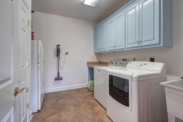 laundry room with washer and dryer, cabinet space, baseboards, and a sink