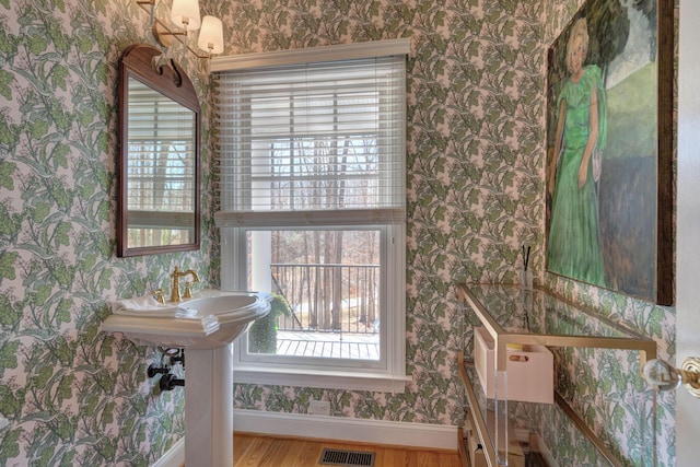 bathroom featuring visible vents, baseboards, wood finished floors, and wallpapered walls