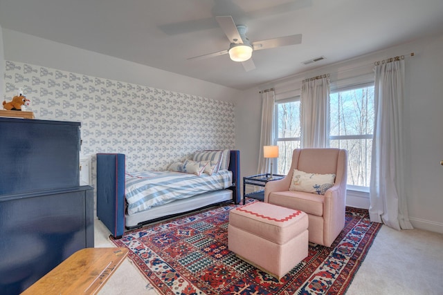 carpeted bedroom featuring baseboards, visible vents, wallpapered walls, and ceiling fan