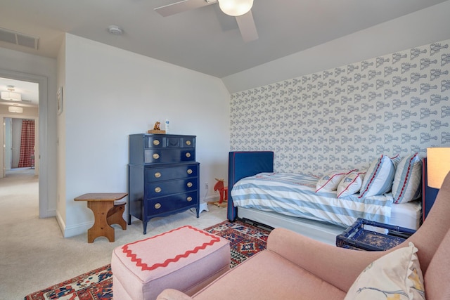 carpeted bedroom featuring visible vents, a ceiling fan, wallpapered walls, baseboards, and vaulted ceiling