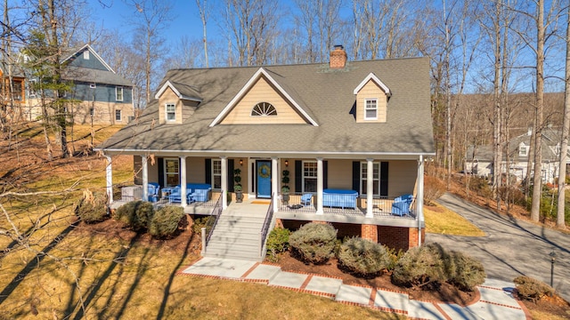 view of front of property with stairway, covered porch, and roof with shingles