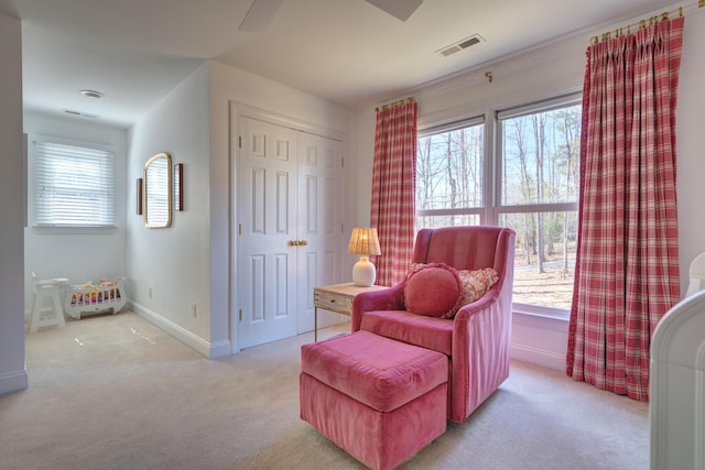 sitting room featuring visible vents, plenty of natural light, carpet flooring, and baseboards