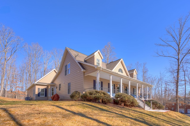 view of home's exterior with central air condition unit, a lawn, and covered porch