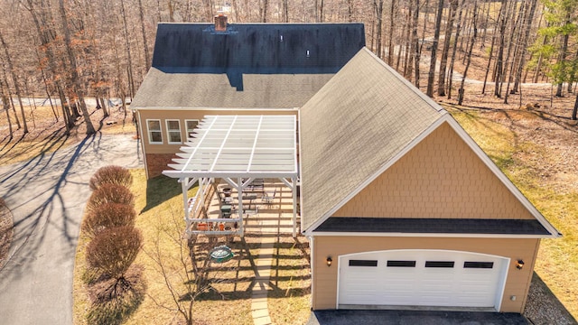 view of front of property with stairway, a garage, driveway, and a shingled roof