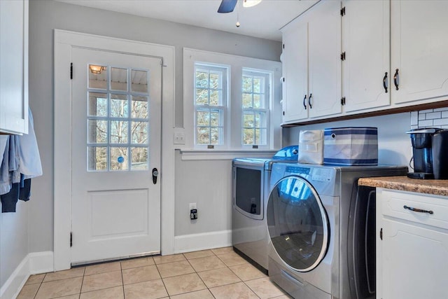 washroom featuring cabinet space, ceiling fan, baseboards, light tile patterned floors, and washer and clothes dryer