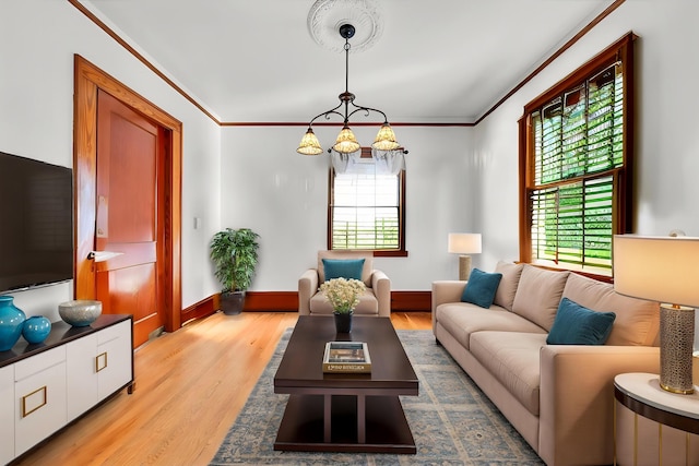living room with plenty of natural light, light wood-style floors, crown molding, and baseboards