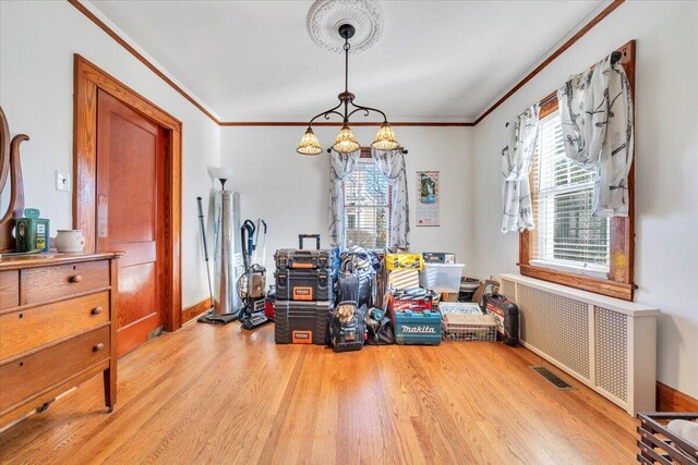 dining area with plenty of natural light, light wood-style floors, and ornamental molding