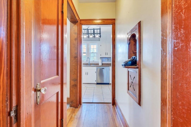 hall featuring light wood finished floors and a sink