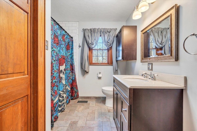 bathroom featuring visible vents, toilet, stone finish flooring, a textured ceiling, and vanity