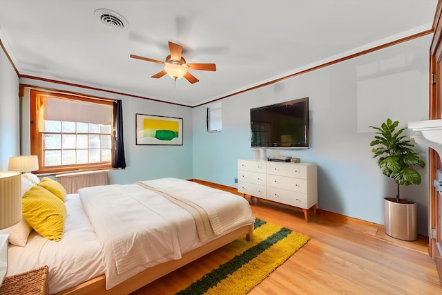 bedroom with crown molding, a ceiling fan, baseboards, light wood-type flooring, and visible vents