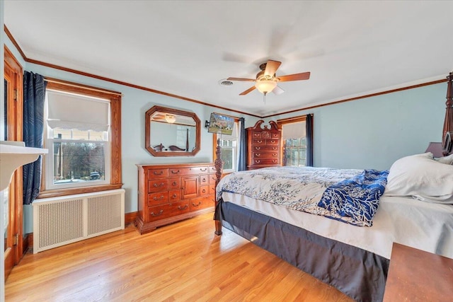 bedroom with multiple windows, radiator heating unit, wood finished floors, and ornamental molding