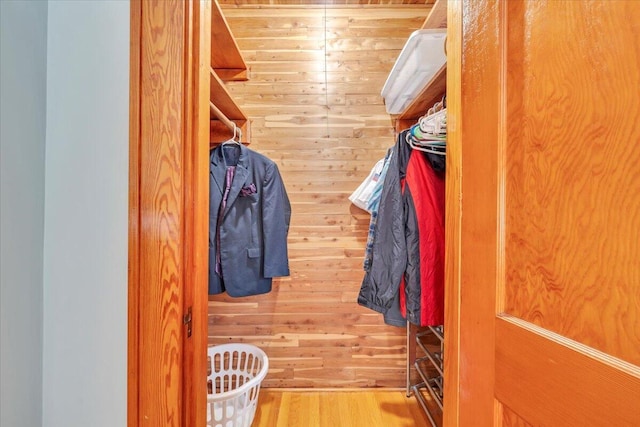 walk in closet with wood finished floors