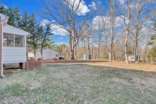 view of yard with a storage shed, an outbuilding, and a sunroom