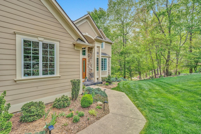 view of exterior entry with a lawn