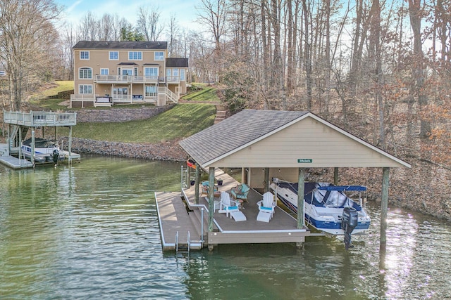 view of dock with boat lift, stairs, a yard, and a water view