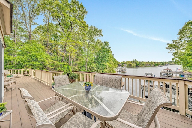 wooden terrace featuring outdoor dining area and a water view