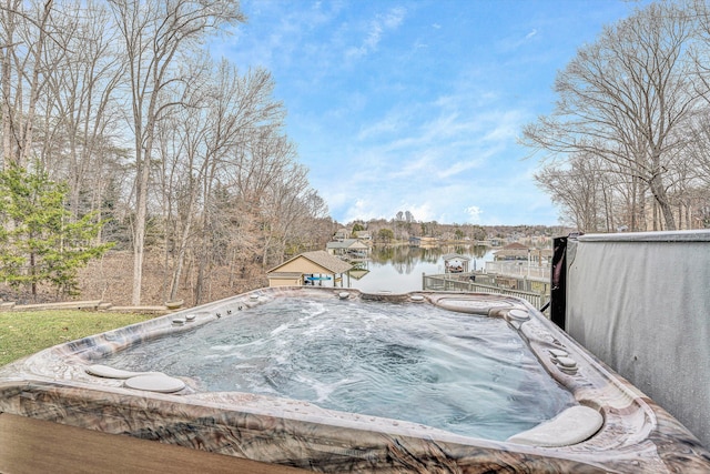 exterior space with a hot tub and a water view