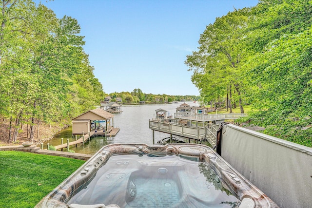 dock featuring a water view, a hot tub, boat lift, and view of scattered trees