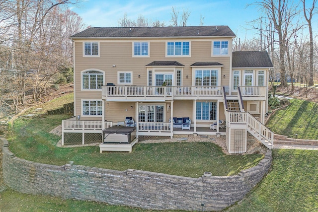 back of house with stairway, a lawn, a hot tub, and a wooden deck