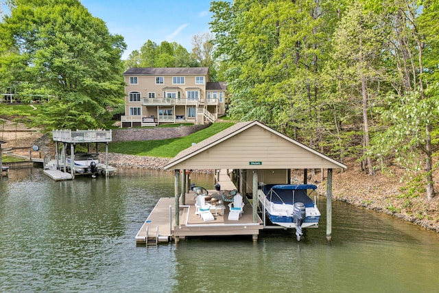dock featuring boat lift, a water view, and a yard