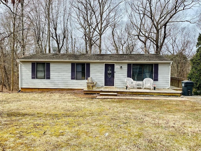 ranch-style house featuring a deck and a front yard