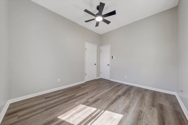 empty room featuring a ceiling fan, wood finished floors, and baseboards