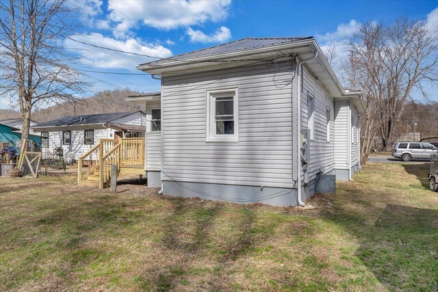 view of property exterior with a lawn and metal roof