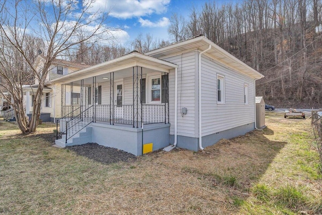 bungalow with crawl space, covered porch, and a front lawn