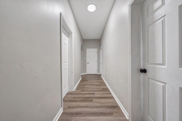 hall featuring baseboards and wood finished floors