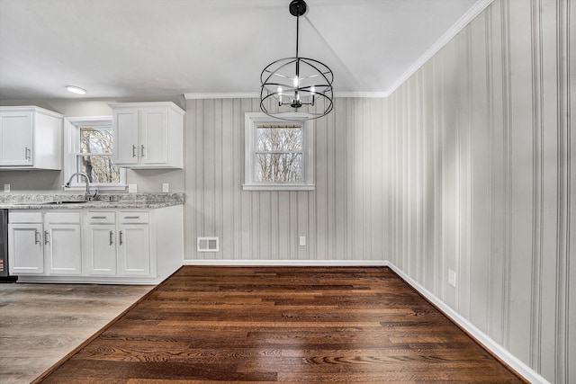 unfurnished dining area featuring plenty of natural light, wood finished floors, visible vents, and a sink