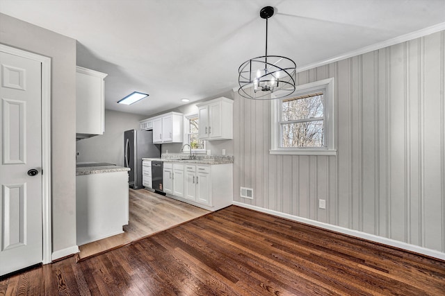 kitchen featuring visible vents, light wood-style flooring, a sink, freestanding refrigerator, and white cabinetry