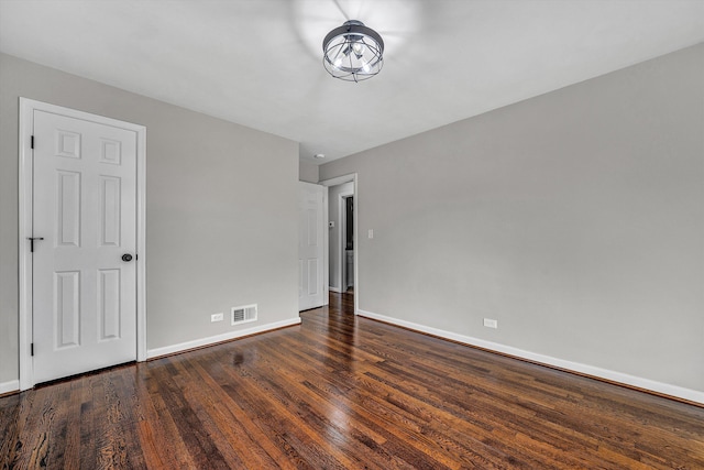 empty room featuring visible vents, baseboards, and wood finished floors