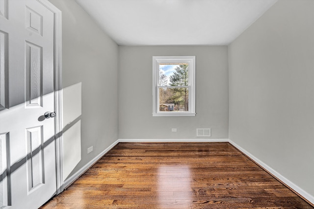 unfurnished room featuring visible vents, baseboards, and wood finished floors