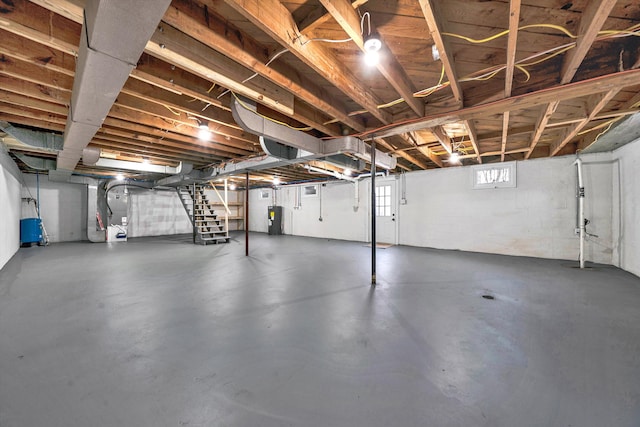 below grade area featuring stairs, heating unit, and water heater