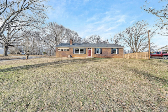 ranch-style home featuring a front lawn, fence, brick siding, and a chimney