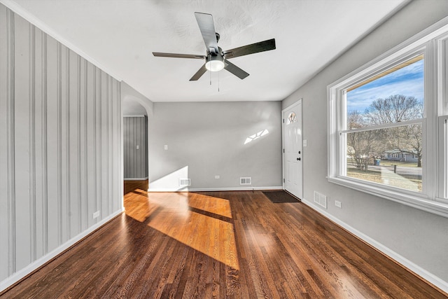 interior space featuring a ceiling fan, wood finished floors, visible vents, and baseboards