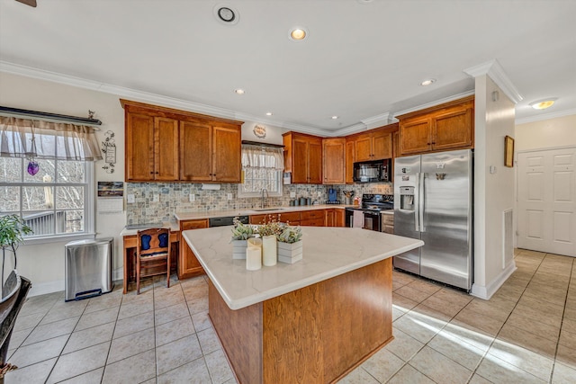 kitchen featuring black appliances, a sink, tasteful backsplash, light tile patterned flooring, and brown cabinetry