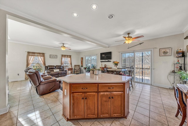 kitchen featuring a center island, light tile patterned flooring, open floor plan, and ornamental molding