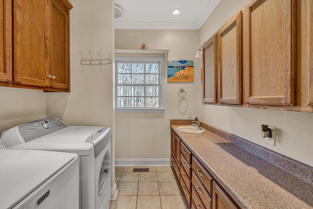 washroom featuring crown molding, baseboards, light tile patterned floors, separate washer and dryer, and a sink