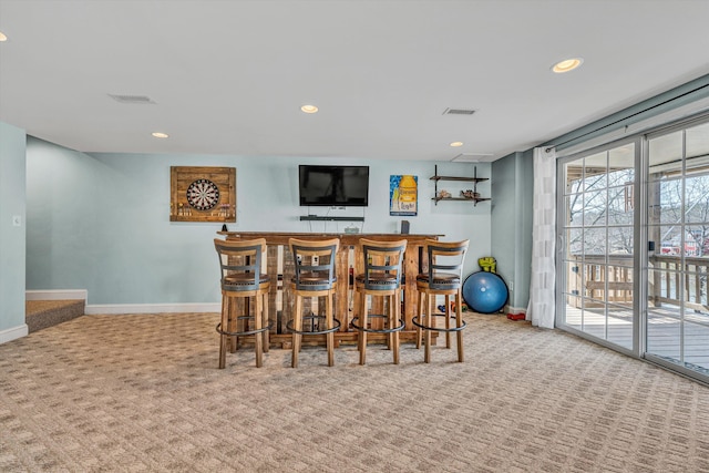 dining space featuring carpet flooring, recessed lighting, baseboards, and indoor bar