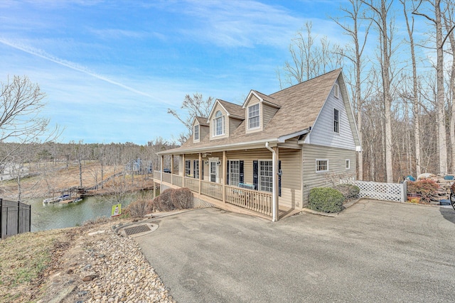 view of front of house with a porch and a water view