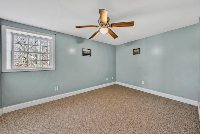 carpeted empty room featuring baseboards and a ceiling fan