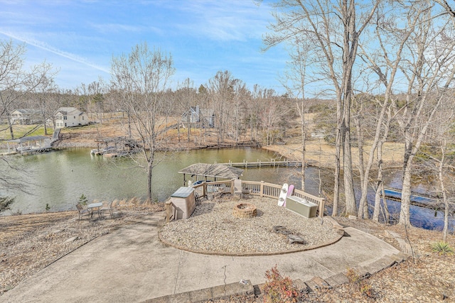 exterior space featuring a water view and a fire pit